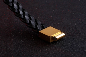 Macro shot of black braided leather bracelet with golden square magnetic clasp detail