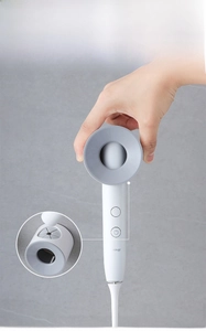 Macro view of grey silicone holder band securing an electric toothbrush to the wall