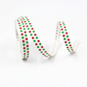 Close-up of 10mm white grosgrain ribbon featuring festive red and green polka dot patterns