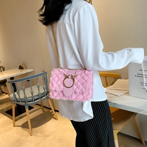 Pink plush crossbody bag with gold chain strap and antler ring detail on model