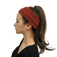 Detail view of a knitted orange headband showing the ribbed texture and comfortable fit