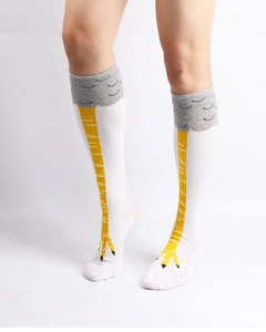 Detail of creative chicken feet knee-high socks featuring yellow claw pattern on white fabric