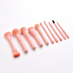 Set of 10 professional pink makeup brushes for face and eyes on a white background