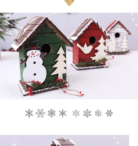 Detailed view of wooden Christmas cabin ornaments with snowman and festive pine accents