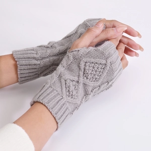 Detail of grey cable-knit fingerless gloves showing diamond pattern and ribbed texture
