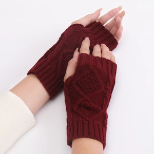 Close-up of wine red knitted fingerless gloves with a textured diamond pattern weave