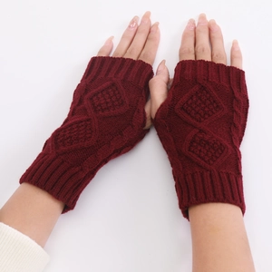 Macro detail of wine red fingerless gloves with diamond cable knit texture and elastic cuffs