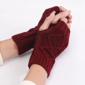 Detail of burgundy knitted fingerless gloves showing diamond and cable knit patterns