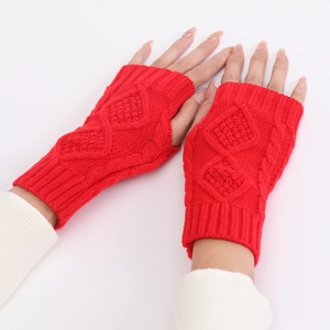 Detail of red knitted fingerless gloves showing the thick weave and diamond pattern texture