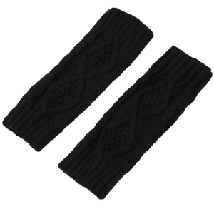 Detail of black knit arm warmers with intricate cable knit texture and diamond pattern