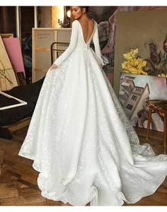 Détail d'une élégante robe de mariée à manches longues avec dos en V profond et dentelle