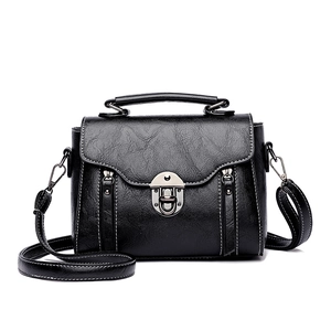 Vintage black crossbody bag with white stitching and silver hardware on white background