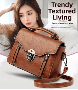 Detail view of brown vintage leather handbag with retro metal buckle and adjustable strap