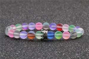 Close-up of frosted moonstone beads and silver crown charm on an elastic bracelet
