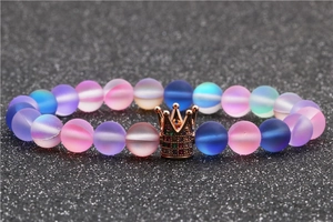 Macro shot of crown bracelet with frosted pastel beads and rose gold alloy charm