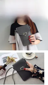Détail du sac de téléphone gris avec boucle coeur dorée et texture cuir élégante