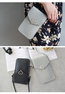 Détail du sac à bandoulière pour téléphone avec fermoir cœur doré et texture cuir