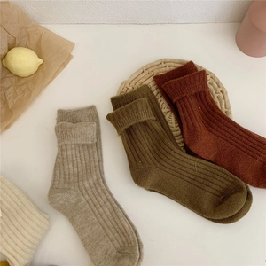 Detailed view of thick wool blend crew socks in beige, olive green, and dark brown colors