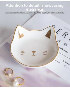 Detailed view of white ceramic cat plate featuring elegant gold rim and facial details