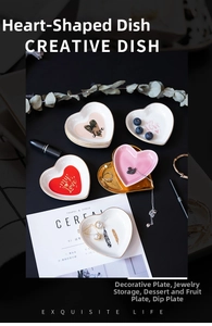 Detailed view of heart-shaped ceramic jewelry dish with gold rim and artistic prints