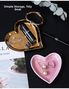 Top view of heart-shaped ceramic and gold metal trays with decorative accessories