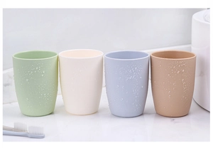 Four minimalist frosted plastic rinse cups in pastel tones on white marble surface