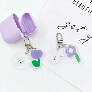Detail view of purple silicone AirPods case with cute dog and flower acrylic charms