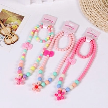 Close-up of colorful resin bead necklace and bracelet sets with floral charms