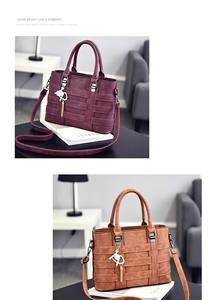 Detail of woven leather texture and cat pendant on burgundy and brown handbags