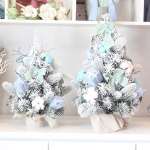 Mini desktop Christmas trees with snow flocking and pastel gift box decorations