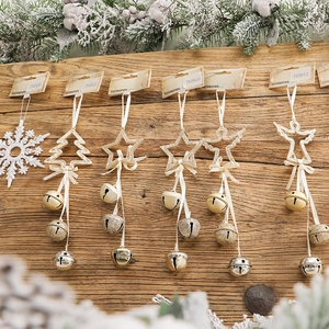 Christmas hanging decorations with bells and snowflake shapes on a wooden wall