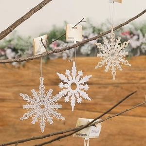 Glitter Christmas snowflake ornaments in silver and gold hanging on rustic branches