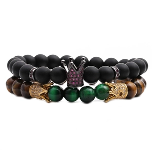 Detailansicht der Armbänder aus mattschwarzen Perlen und Tigerauge mit Kronenanhängern
