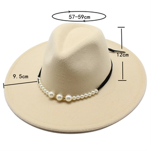 Detail view of beige wool fedora hat with white pearl beads and black ribbon trim