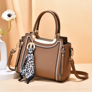 Elegant brown trapezoidal handbag with leopard scarf charm and contrast stitching