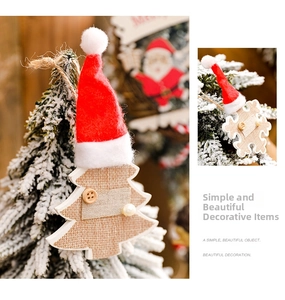 Close-up of burlap Christmas tree and snowflake ornaments with red hats and wooden buttons