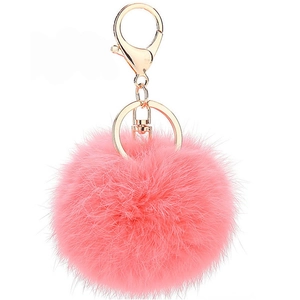 Detail view of a fluffy pink faux fur pompom keychain with shiny gold lobster clasp hardware
