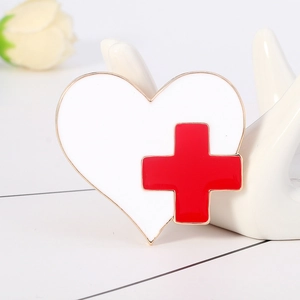 Broche médicale en émail en forme de cœur avec croix rouge et bordure dorée