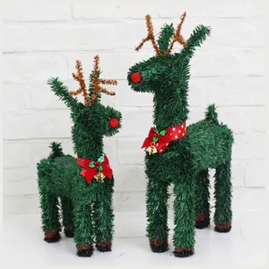 Green tinsel Christmas reindeer pair with red bows and gold bells for festive decor