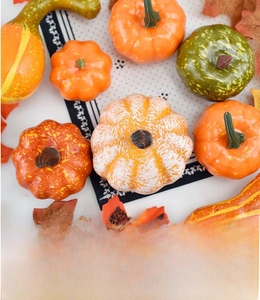 Detail shot of assorted Halloween pumpkins with maple leaves for autumn festive decor