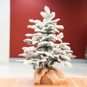 Mini tabletop Christmas tree with flocked snow, pine cones and a rustic burlap base