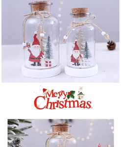 Detail view of miniature Santa Claus and pine tree inside a Christmas glass dome