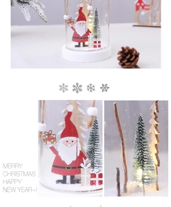 Detail of Christmas glass dome with LED lights, Santa figurine, and festive pine cones