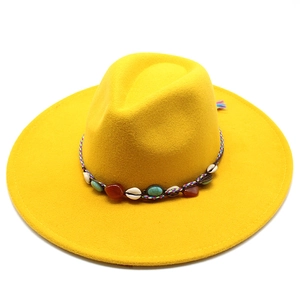 Detail of yellow wool fedora hat with bohemian woven band featuring turquoise and shells