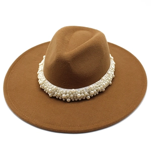 Macro detail of camel wool fedora hat featuring elegant layered faux pearl band decoration