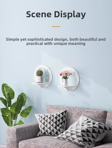 Detail of two white circular wall-mounted floating shelves for small plants and home decor