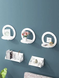 Modern white floating wall shelves set displayed on deep blue wall with decorative items