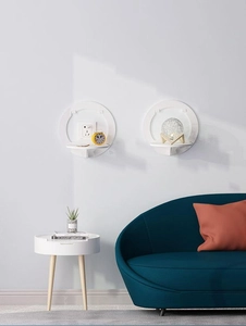 White circular wall-mounted shelf displaying decorative items in a modern living room