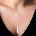 Detailed view of a gold panda pendant necklace with geometric drops on a fashion model