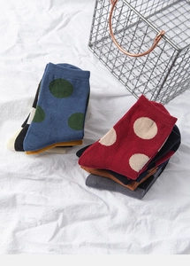 Detail of colorful polka dot cotton socks neatly folded on white fabric background